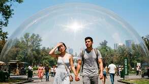 Un gran domo transparente en un parque de México encerrando a una pareja de jóvenes