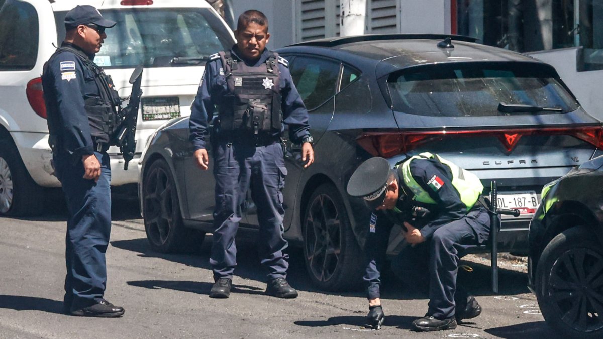 Policías observando balas en el suelo.