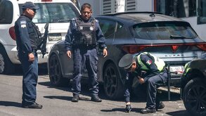Policías observando balas en el suelo.