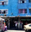 Autos estacionados afuera de un edificio azul en la ciudad de Puebla.