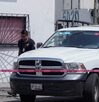 Auto de la Fiscalía de Puebla junto a una cinta roja, con una foto encimada de una michelada.