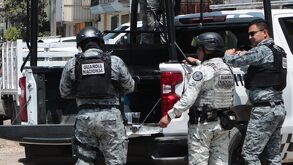 Elementos de la Guardia Nacional recargados sobre una patrulla.