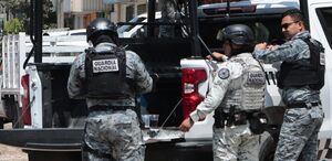 Elementos de la Guardia Nacional recargados sobre una patrulla.