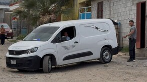 Se observa una camioneta color blanca y dos hombres.