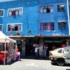 Autos estacionados afuera de un edificio azul en la ciudad de Puebla.