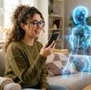 Una mujer en una sala iluminada hablando a través de un teléfono celular con el holograma de un robot