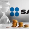 Reloj de arena blanca con pilas de monedas al lado y el logo del SAT desenfocado en el fondo