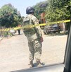 Vista de espaldas de un militar del Ejército Nacional parado detrás de una cinta policiaca en calles de Colima