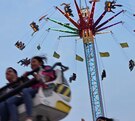 Personas en un juego mecánico volador en la Feria de Puebla.