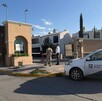 Se observa un carro estacionado, y una fachada de fraccionamiento.