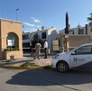 Se observa un carro estacionado, y una fachada de fraccionamiento.