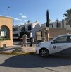 Se observa un carro estacionado, y una fachada de fraccionamiento.