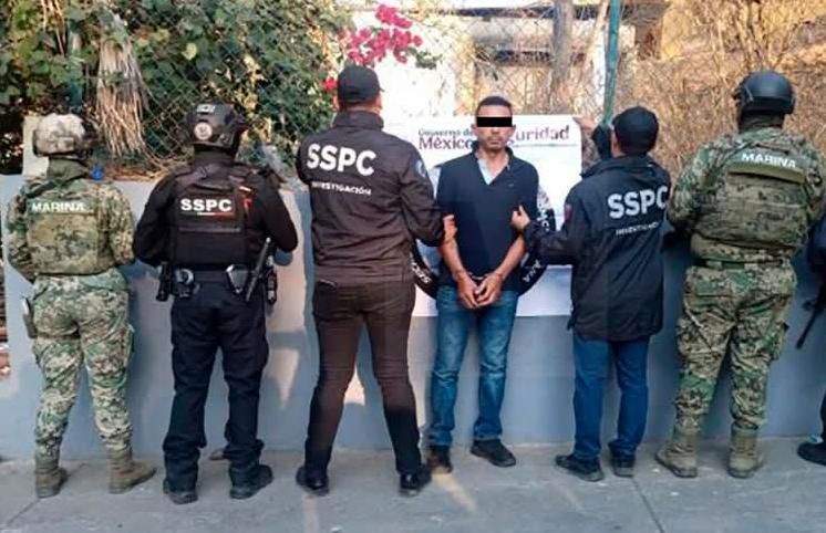 Hombre detenido con policías a los lados