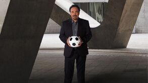 Hugo Sánchez sosteniendo un balón de futbol.