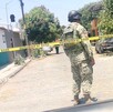 Vista de espaldas de un militar del Ejército Nacional parado detrás de una cinta policiaca en calles de Colima