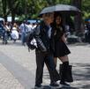 Turistas disfrutan una tarde soleada en Chapultepec con changos de colores y sombrilla para protegerse.
