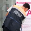 Hombre coloca sello de 'Clausurado' en una clínica de Oaxaca.