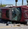 Se observa un automóvil volcado en color rojo y está con daños materiales.