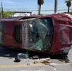 Se observa un automóvil volcado en color rojo y está con daños materiales.