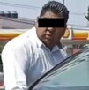 Hombre de camisa blanca azoma la cabeza a un auto blanco para agredir al conductor.