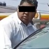 Hombre de camisa blanca azoma la cabeza a un auto blanco para agredir al conductor.