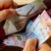 Manos de una persona abriendo una cartera con billetes mexicanos de distinta denominación