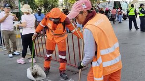 Mujeres trabajadoras del servicio de limpieza en Puebla barriendo basura de una de las calles de la capital