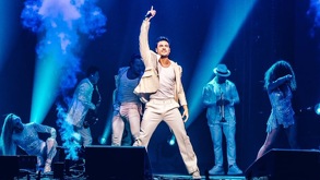 Carlos Rivera durante una de sus presentaciones vestido de mariachi con fondo tradicional de Día de muertos