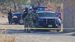Militares del Ejército Mexicano junto a patrullas y oficiales de la Policía de Tonalá en un terreno baldío acordonado por una cinta policiaca