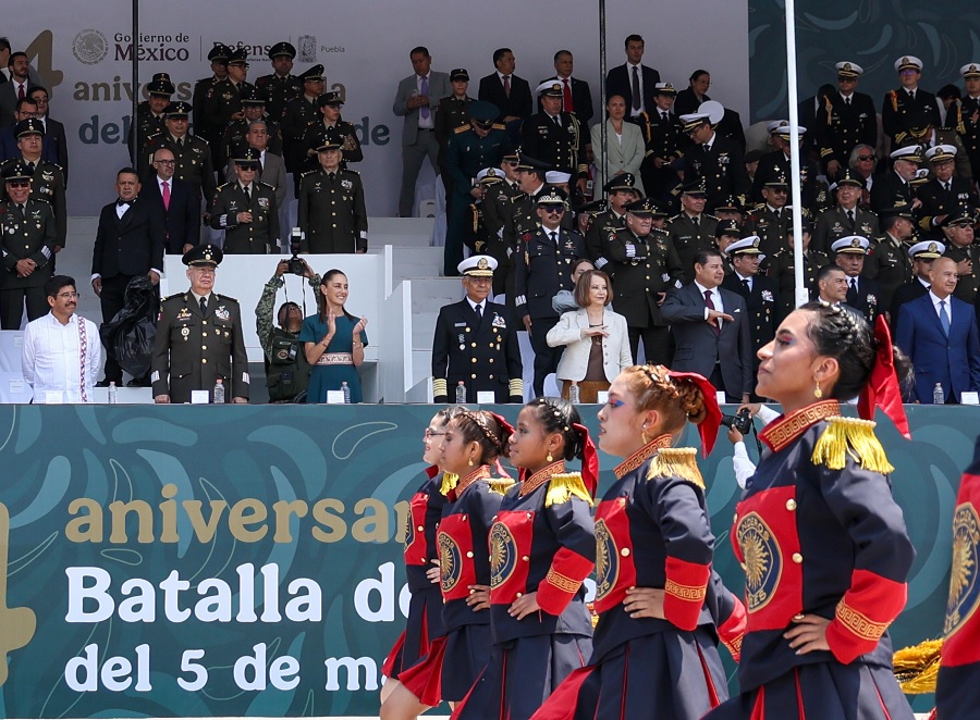 Grupo de mujeres desfilan frente a Claudia Sheinbaum un 5 de mayo en Puebla.