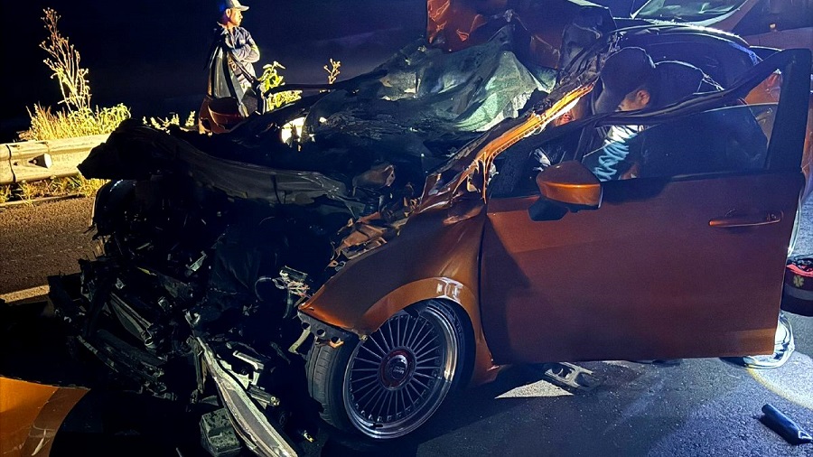 Coche anaranjado destrozado de la parte frontal.