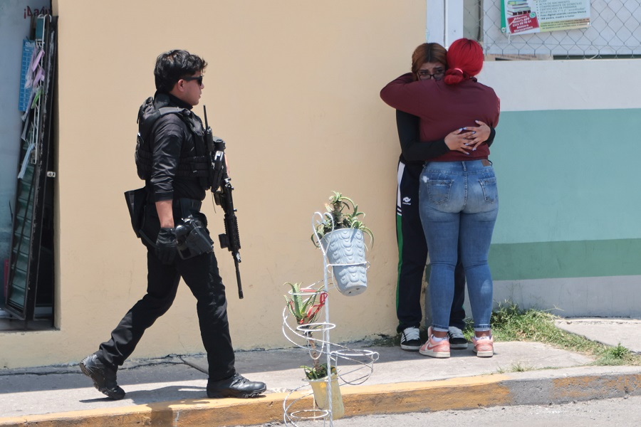 Dos mujeres se abrazan tras una balacera en el Mercado Morelos de Puebla.