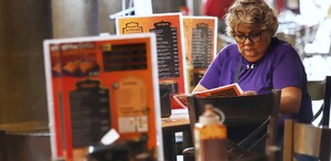 Mujer adulta leyendo la carta en un restaurante.