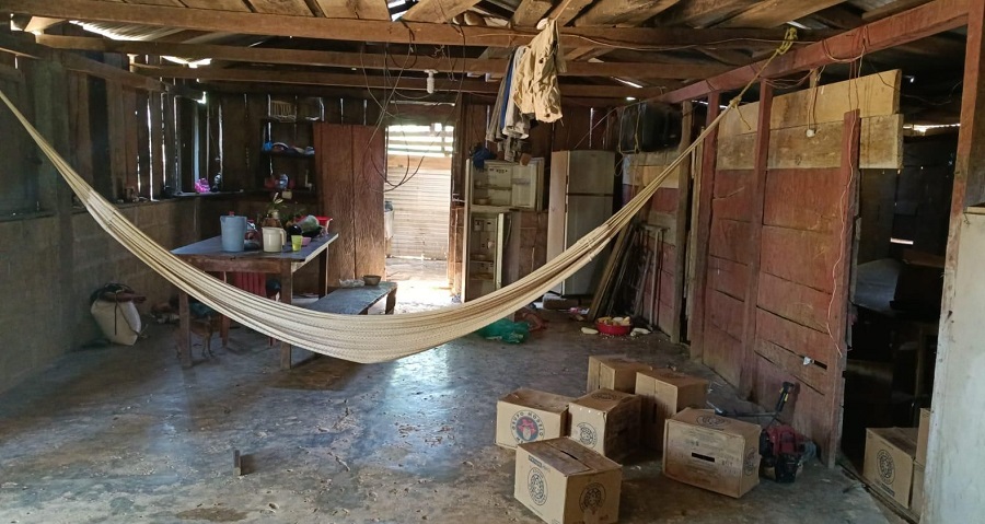 Vivienda con una hamaca y cartones de cerveza.