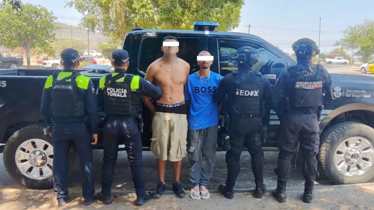 Dos hombre detenidos y con los ojos censurados por un recuadro blanco con policías de Tonalá y Jalisco a los lados enfrente de una patrulla