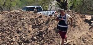 una mujer cruza un camino bloqueado