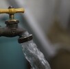 Se observa una llave y sale de ella un chorro de agua.