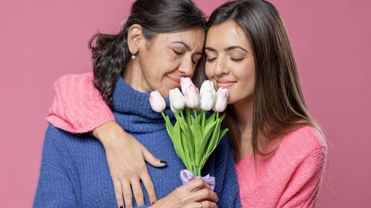 Mujer regalando flores a su mamá por el Día de las Madres