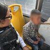 Niño con el rostro censurado con blur sentado en un camión del transporte público al lado de una policía de la Secretaría de Seguridad Jalisco