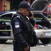 Policía hablando por teléfono junto a un vehículo asegurado.