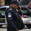 Policía hablando por teléfono junto a un vehículo asegurado.