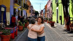 Madre e hija abrazadas en las calles de Puebla