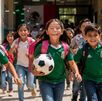 Niños con playera de la selección mexicana felices saliendo de vacaciones