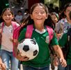 Niños con playera de la selección mexicana felices saliendo de vacaciones