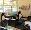 Salón de clases con estudiantes sentados en pupitres