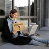 Mujer trabajando en el suelo con un sobre en la mano que dice utilidades y un signo de interrogación