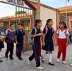 Niños menores saliendo de escuela primaria mientras caminan