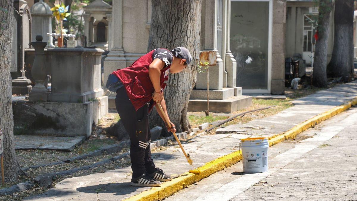 Mujer barre el piso del Panteón Municipal con artículos de limpieza