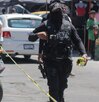 Policía coloca cinta de seguridad junto a una motocicleta.