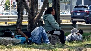 Mujer sentada en una piedra afuera del Hospital del Niño Poblano.